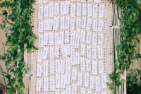 24 a woven tray with letter press escort cards attached and a lush greenery garland with blooms on top