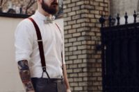 24 grey pants, a white shirt and rust-colored suspenders with a light-colored bow tie