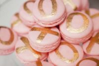 24 pink macarons with metallic letters for serving at a glam bridal shower