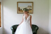 25 A-line wedding dress with a bodice and thick straps decorated with floral appliques, a covered plunging neckline and a tulle skirt