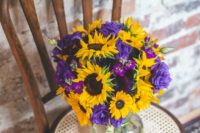 25 a bold floral centerpiece of purple and yellow flowers for a rustic wedding