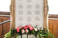 25 an elegant seating chart in a refined vintage frame and with a floral posie and greenery