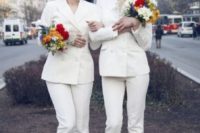26 two bride wearing same pantsuits with cropped pants, statement earrings and snake print shoes