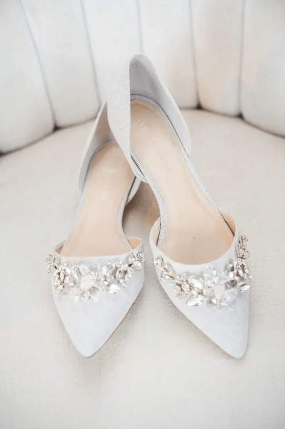Off white pointed toe flats with large floral embellishments for a romantic feel