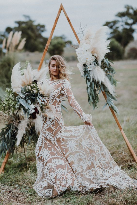 a boho triangle wedding arch with foliage, herbs and pampas grass, which is another hot trend