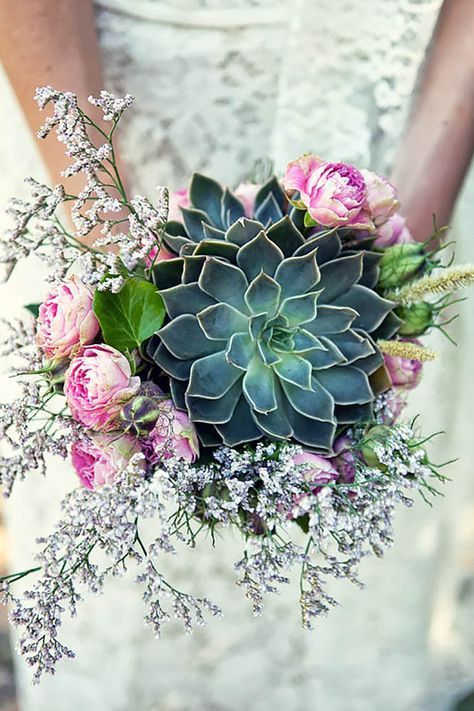 a gorgeous wedding bouquet with a large succulent, some lilac and pink blooms around