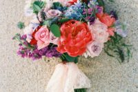 03 a cool colorful wedding bouquet in red, mauve, pink, blue and purple plus lace and blush ribbons hanging down