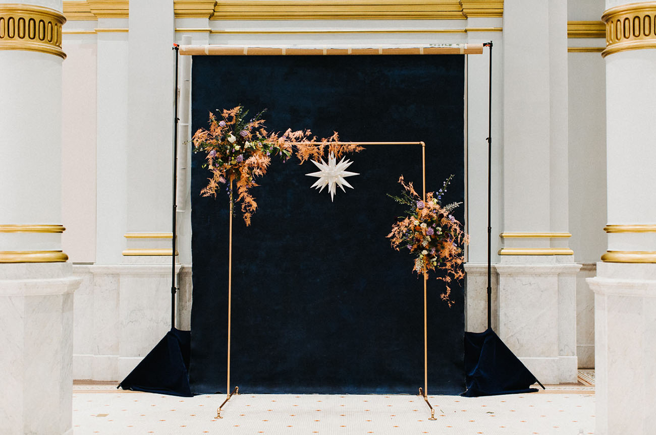The amazing wedding arch was done of gold piping, a star and large moody asymmetrical florals