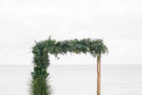04 a branch wedding arch decorated with lush tropical leaves for a tropical beach wedding