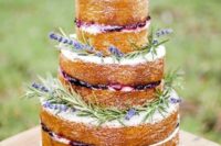 04 a country chic naked wedding cake with berries, lavender and a pinecone and a white rose on top