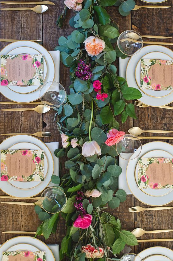 a fresh floral and greenery garland, floral menus and gold flatware for a cute garden-inspired tablescape