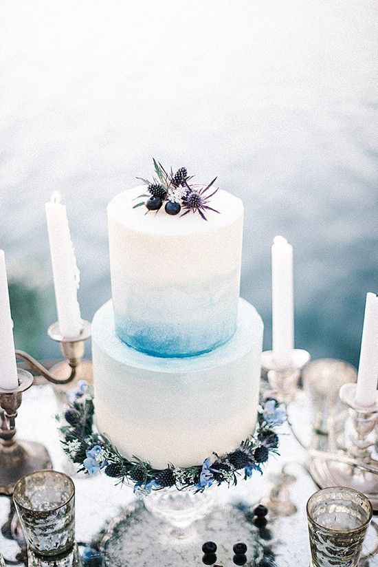 an ombre blue wedding cake decorated with blue thistles and blueberries for a sea feel