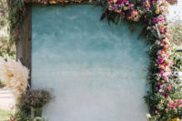 06 The wedding backdrop was an ombre blue one, with quotes and lush florals and greenery