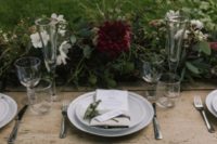 06 The wedding tablescape was done with lush greenery and some blooms, clear glasses, neutral flatware and plates