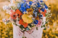 06 a bold wildflower bouquet in the shades of blue, orange, yellow and with blush ribbons