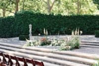 06 a chic garden wedding altar with some neutral blooms and greenery up the steps and a greenery wall