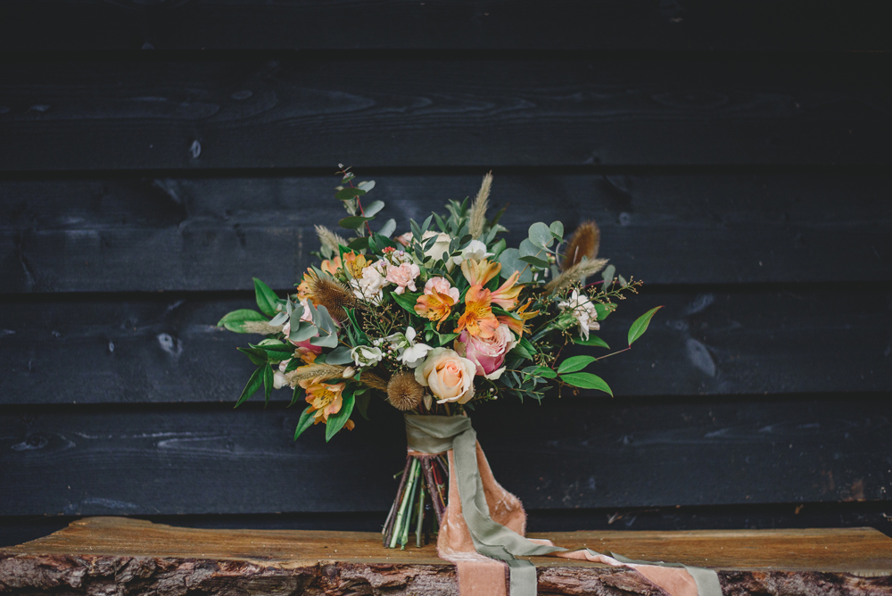 The wedding bouquet was done with herbs and orange and blush blooms