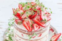 07 a naked strawberry wedding cake with cut berries and some greenery on top screams summer