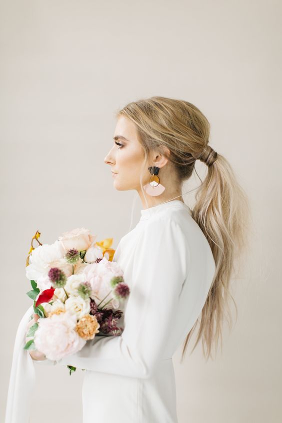a usual messy ponytail with a texture, a volume on top is ideal for a modern or minimalist bride