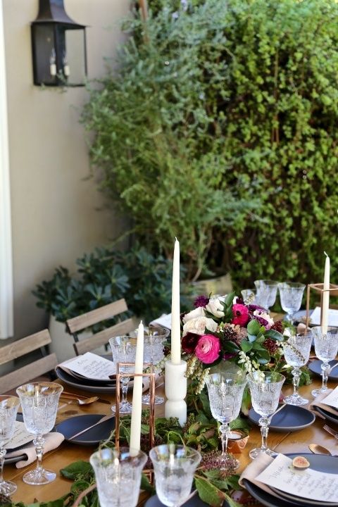 lush table decor with graphite grey plates, bold blooms, crystal glasses and candles plus greenery for a fall garden shower