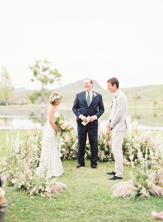 a grass and pastel bloom semicircular wedding altar looks soft and catchy