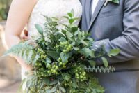 a textural and a bit cascading greenery bridal bouquet with berries for a catchy modern look