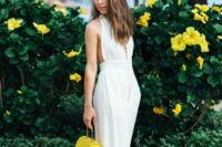08 a white fitting plunging neckline jumpsuit with culottes and a neone yellow little bag for a wow effect