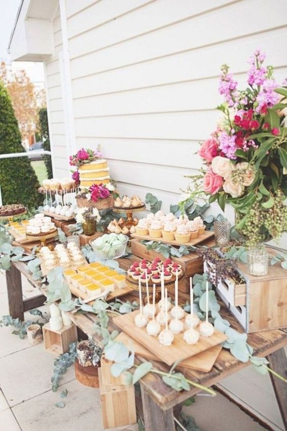 a garden shower sweets table with lush florals and greenery, much eucalyptus makes the table feel fresh