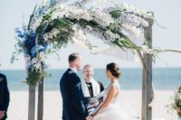 09 an aged wood wedding arch with breezy flower decor in blue, white and lilac blooms
