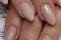 09 nude manicure with touches of glitter on some nails will add a glam feel to your look