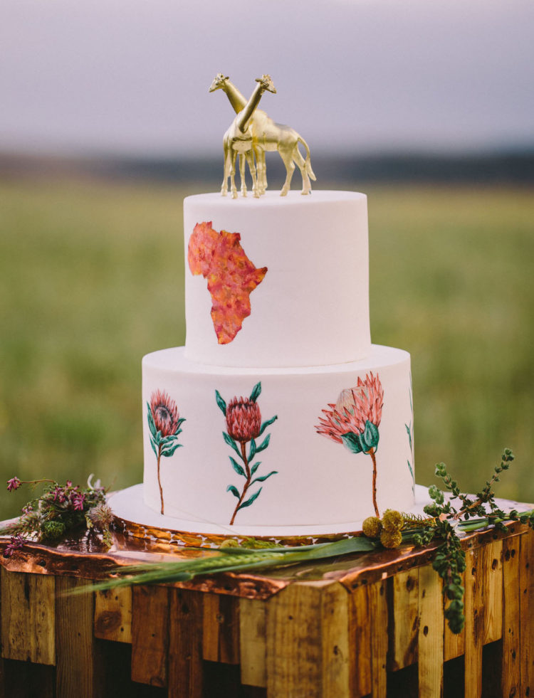 The wedding cake was with handpainted king proteas, African continent and gold giraffe cake toppers