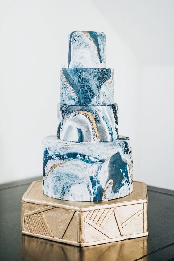a fantastic wedding cake in the shades of blue and gold portraying an ocean surface