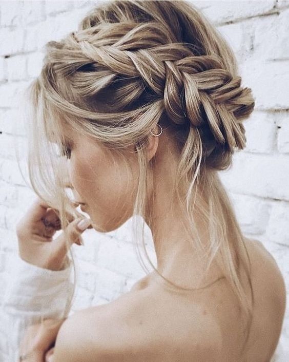 a dimension fishtail halo braided updo with some locks down for a boho chic look