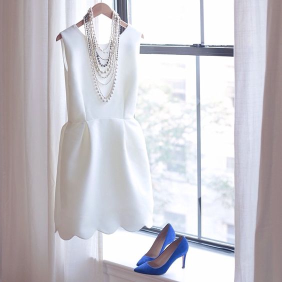 a sleek sleeveless mini dress with a scallop edge, layered necklaces and blue shoes for something blue