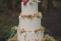 13 The white wedding cake was decorated with dry herbs, berries and greenery