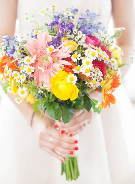 a very colorful wedding bouquet in pink, fuchsia, yellow and purple with a messy wildflower-inspired look