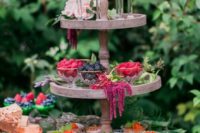 13 gorgeous desserts, cupcakes, berries and souffle served on a stand with flowers and greenery garlands to give it a garden feel