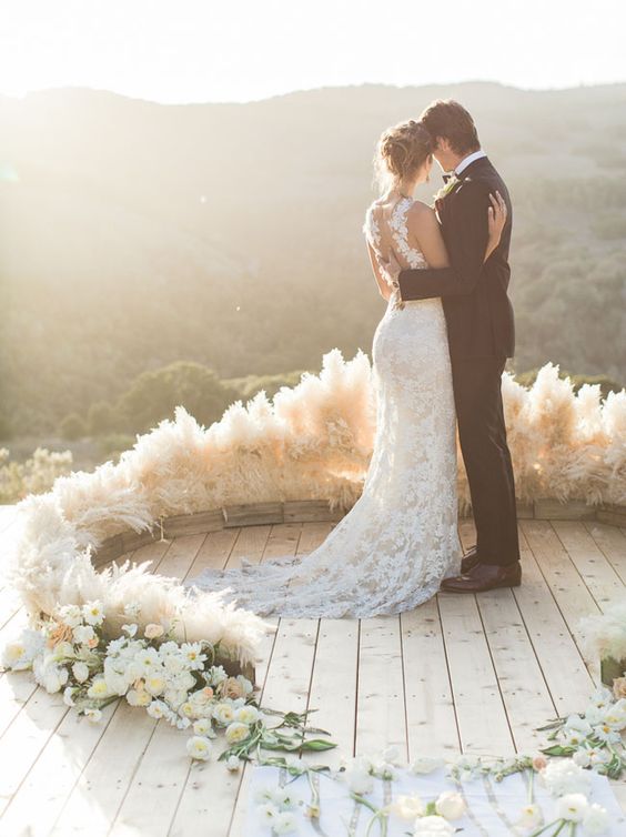 a chic semi circular wedding arch of pampas grass and some white blooms for a textural look