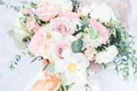 15 a large and lush bouquet with white and pink blooms and eucalyptus for a pastel touch