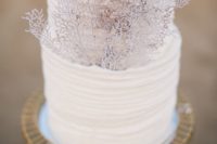15 a white ruffled wedding cake decorated with corals is a stylish way to pull of a beach look