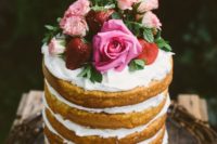 16 a naked wedding cake with whipped cream, fresh strawberries and pink roses for a garden summer wedding