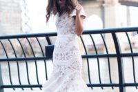 17 a fitting white lace midi dress with short sleeves and a ruffled skirt, white shoes and a black clutch