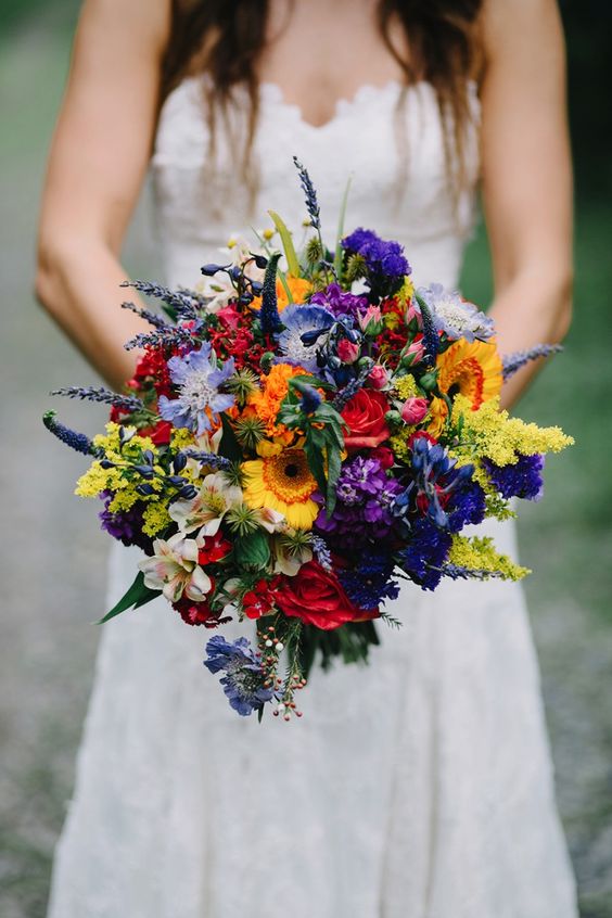a wildflower wedding bouquet with red, yellow, orange, purple, lavender and greenery for a bold look