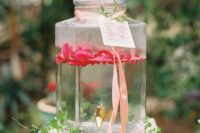 17 rose water in a large clear glass tank with ribbons, a tag and greenery is a great idea for a romantic garden shower