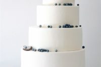18 a beautiful white seaside wedding cake with blueberries as dark pearls and sugar shells