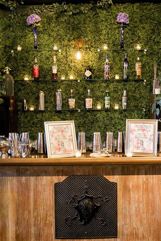a living wall as a bar backdrop and glass shelves not to spoil the look