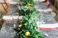 18 a lush and textural greenery table runner with fruits and yellow flowers incorporated for a bold look