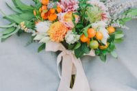 18 a wedding bouquet in the shades of orange, cream and pink, with greenery and litle kumquats plus blush ribbons