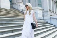 20 a loose white lace midi dress with cap sleeves and a high neckline, black laser cut shoes and a large black clutch