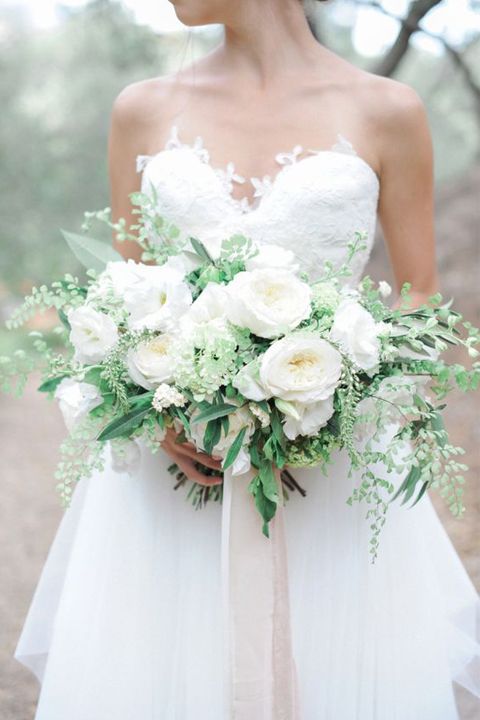 a lush all-white wedding bouquet with greenery and neutral ribbons hanging down is a timeless option